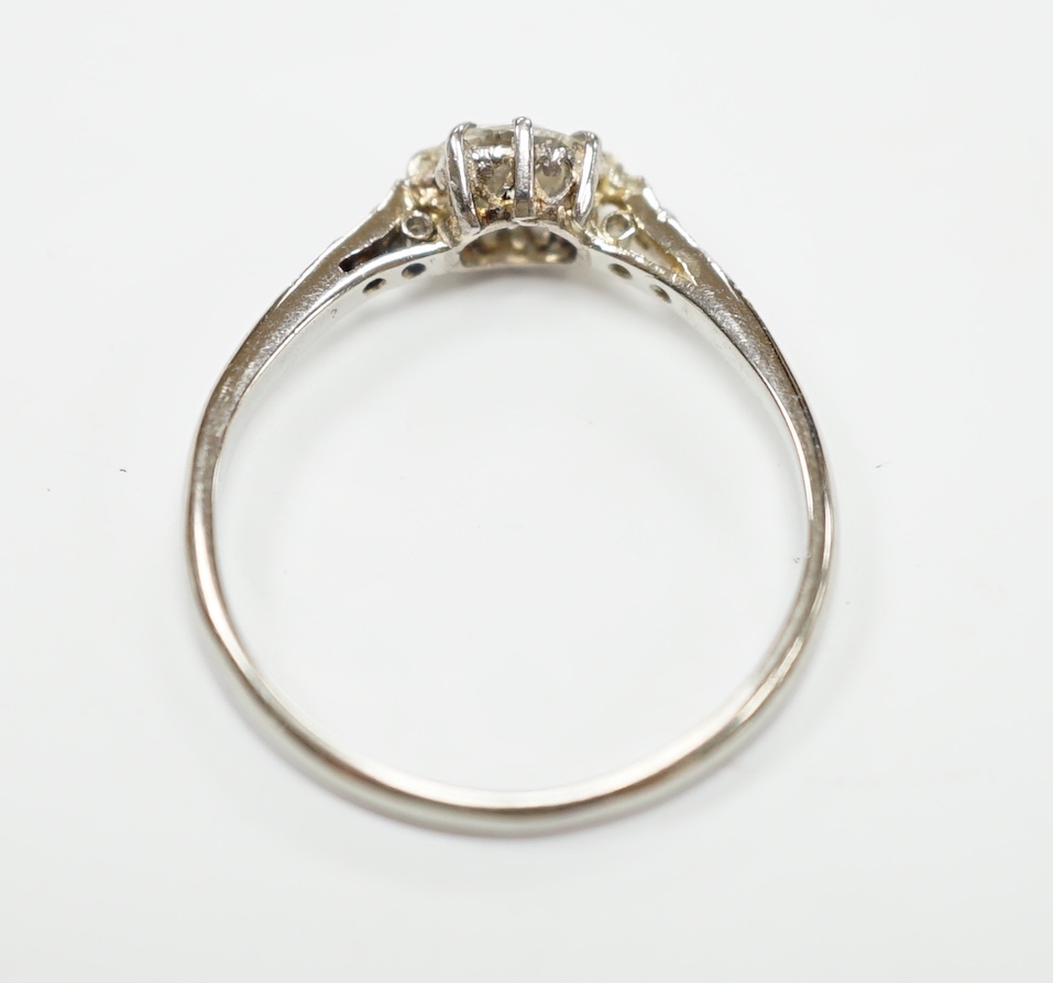 An 18ct, plat. and single stone diamond ring, with diamond set shoulders, size M/N, gross weight 1.9 grams.
